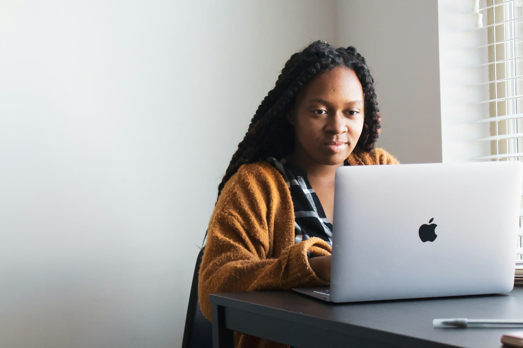 A woman working on her laptop in a bright workspace