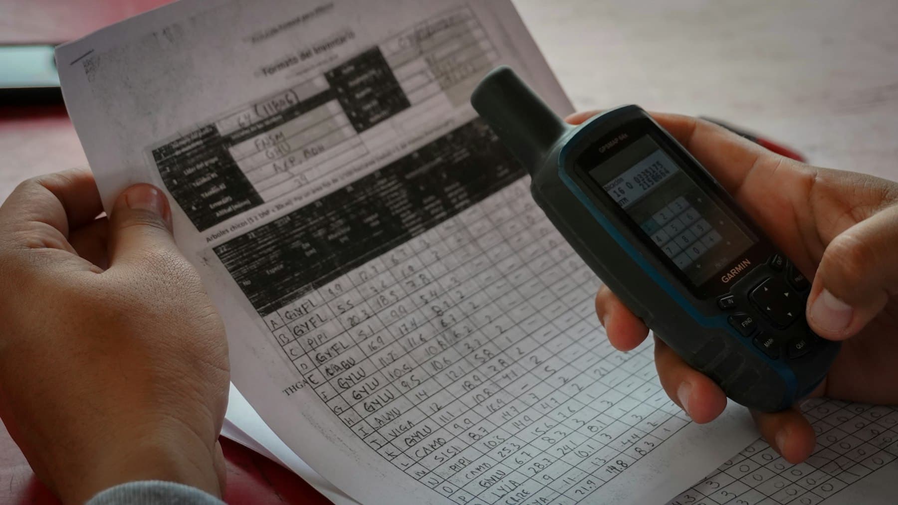 A person photographing a paper document with a phone